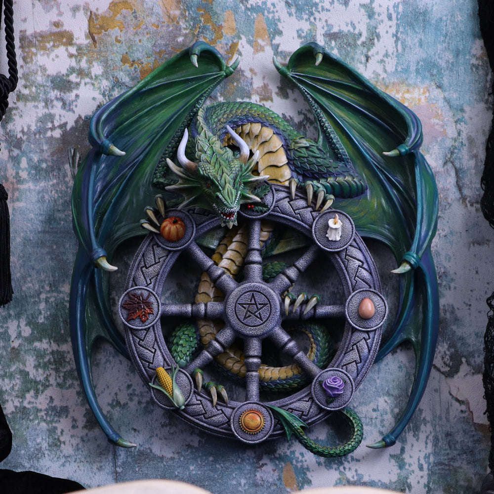 A 30cm wall plaque featuring a green dragon with a Pagan wheel of the year design, hand-painted and made from resin on display