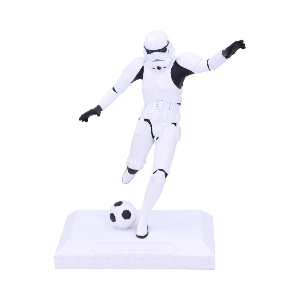 A figurine of a Stormtrooper from Star Wars dressed as a soccer player, about to kick a football, placed on a white base.