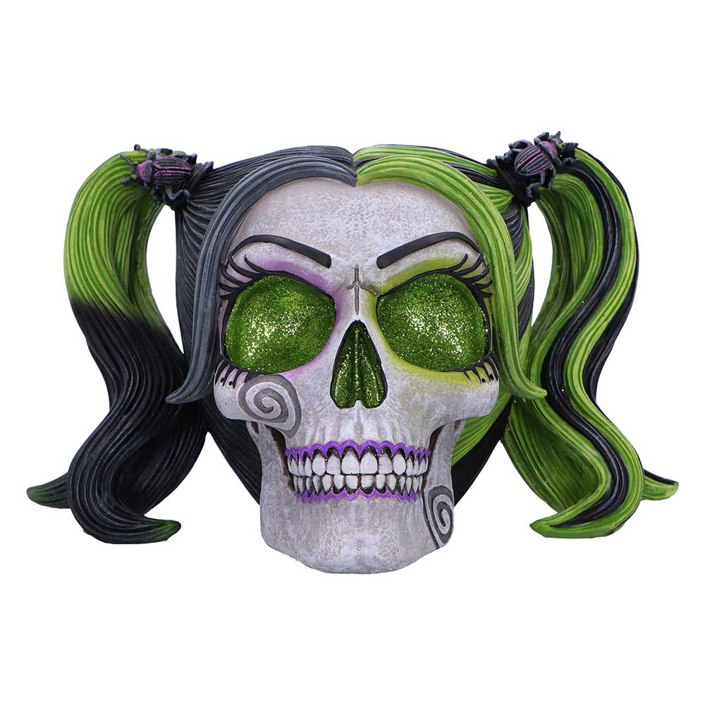 Skull with green and black hair styled in pigtails