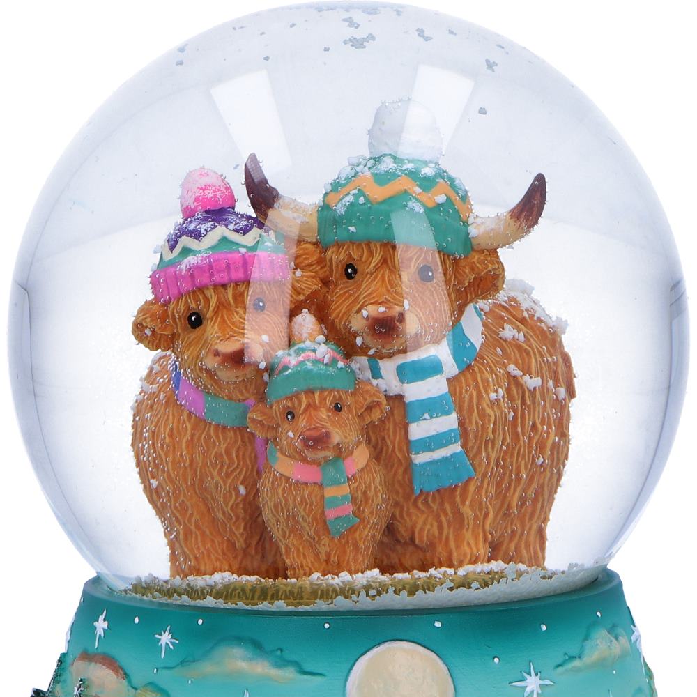 Winter Highland Cow Snow Globe with snow swirling around the Highland cow family after being shaken.