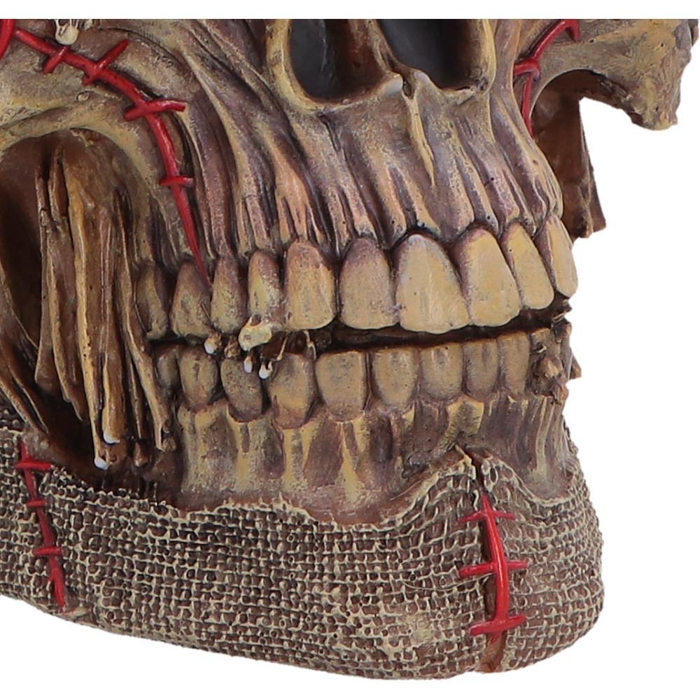 Close-up of a decorative Gothic harvest skull figurine with red stitches