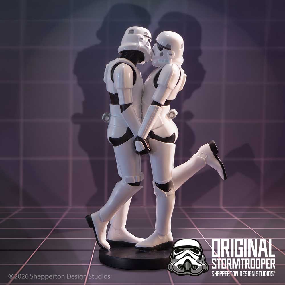 A pair of white stormtrooper figurines posed together, embracing with one leg raised, standing on a round black base on display