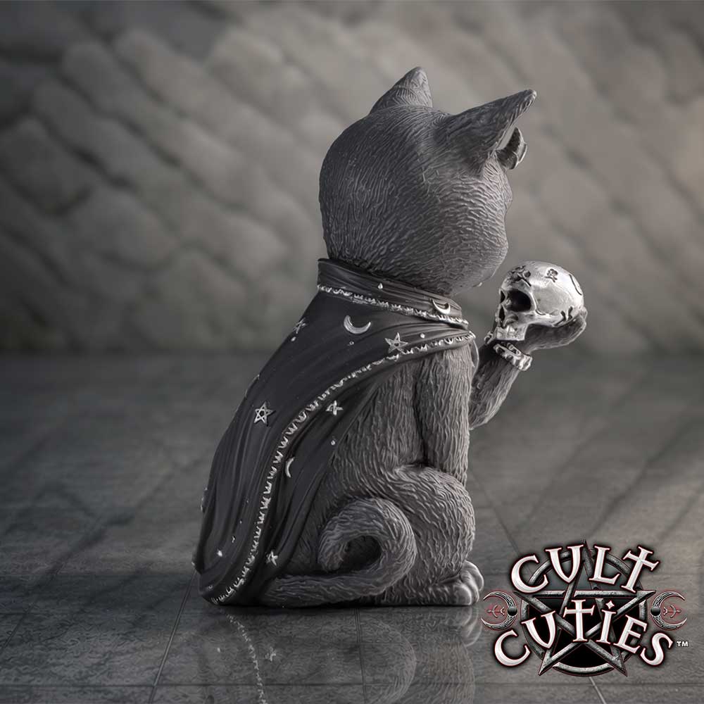 A gothic cat figurine sitting with its back to the camera, wearing a black celestial-patterned cloak and holding a silver skull. The figurine is set against a dark, textured background with a 'Cult Cuties' logo in the bottom right corner.