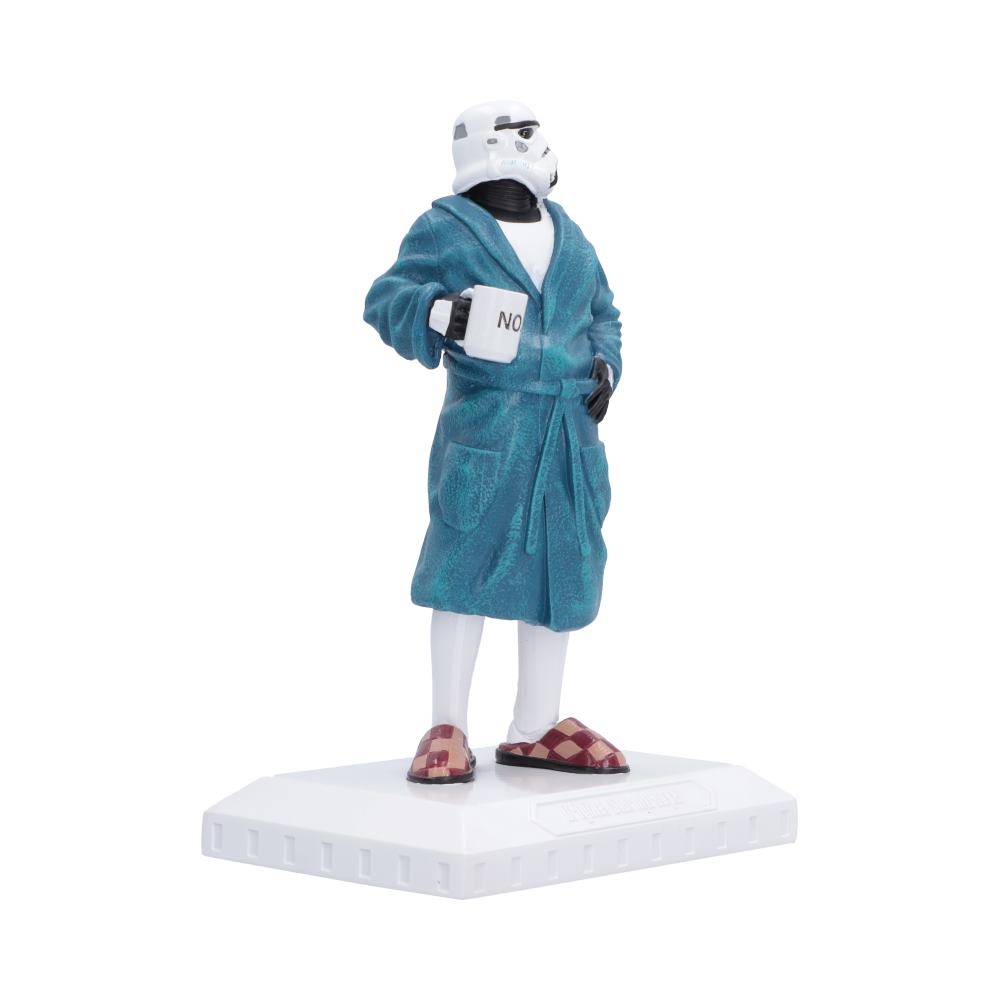 A collectible figurine of a Star Wars Stormtrooper wearing a teal blue bathrobe, white tights, and checkered slippers, holding a mug that says 'NO'. The figurine stands on a white rectangular base