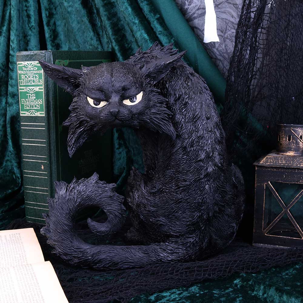 A hand-painted resin figurine of a large black cat with a contemplative expression displayed in a gothic setting