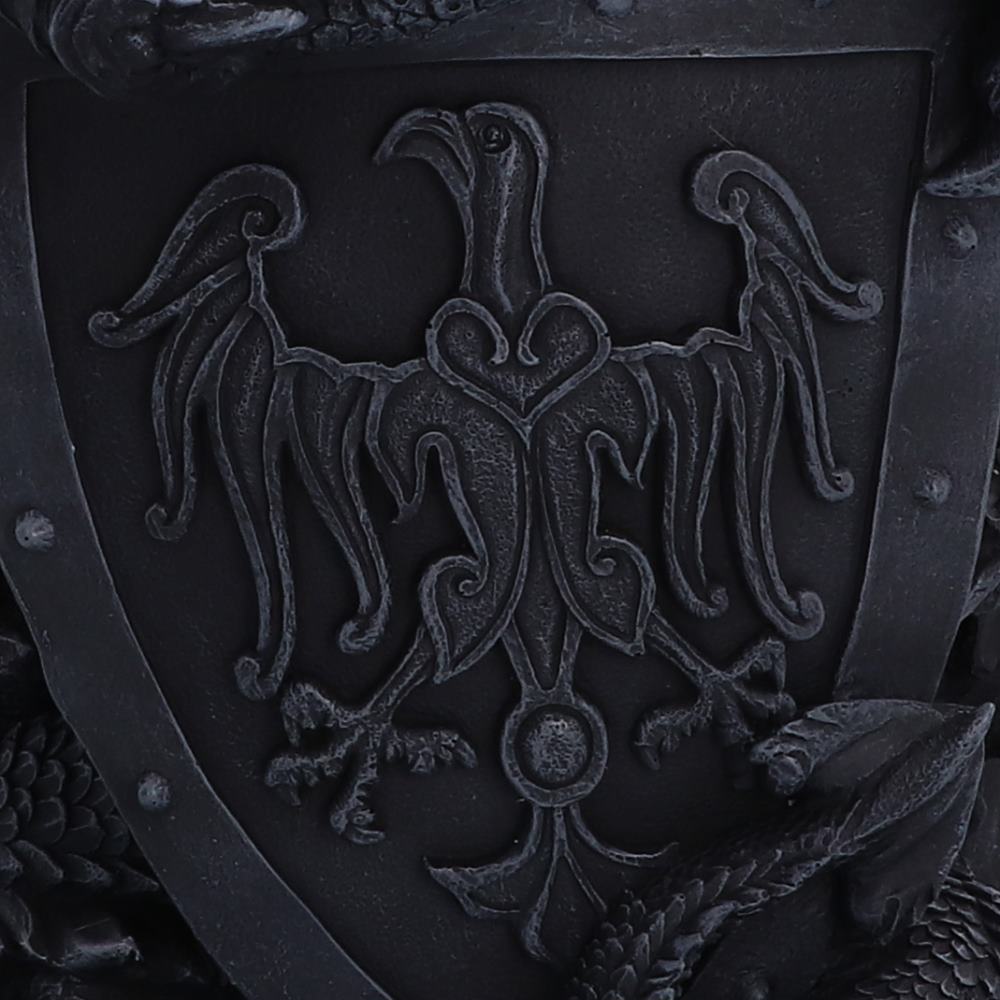 Close-up of a dark metallic shield featuring a raised double-headed eagle emblem with outstretched wings and ornate scrollwork details.