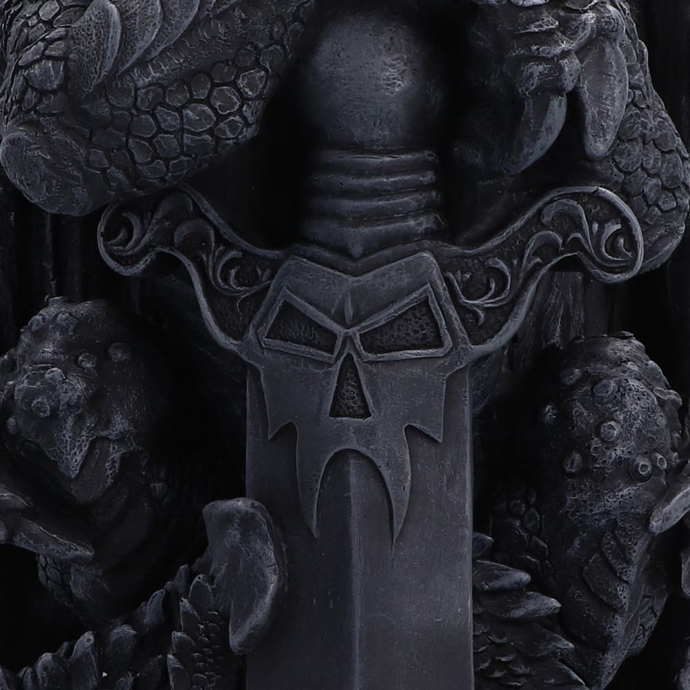 A close-up of a dark, gothic-style decorative sword hilt featuring a skull-like emblem on the blade