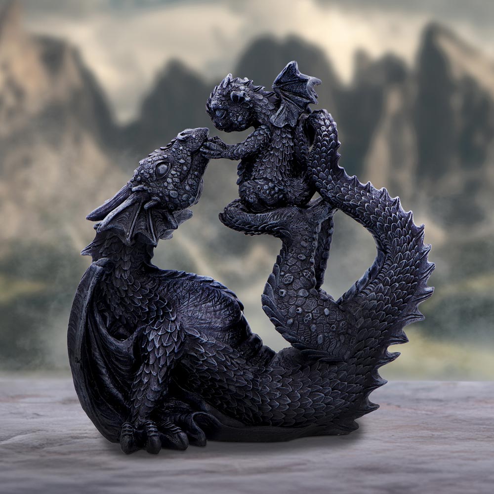 A black resin figurine of a dragoness reclining and cradling a small dragon in her arms, showcasing detailed scales and wings on display