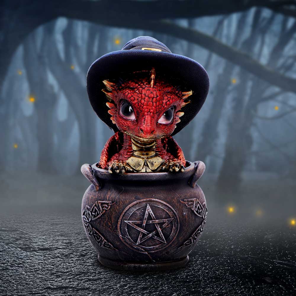 Red dragon figurine in a black hat inside a pentagram symbolized gothic cauldron on display