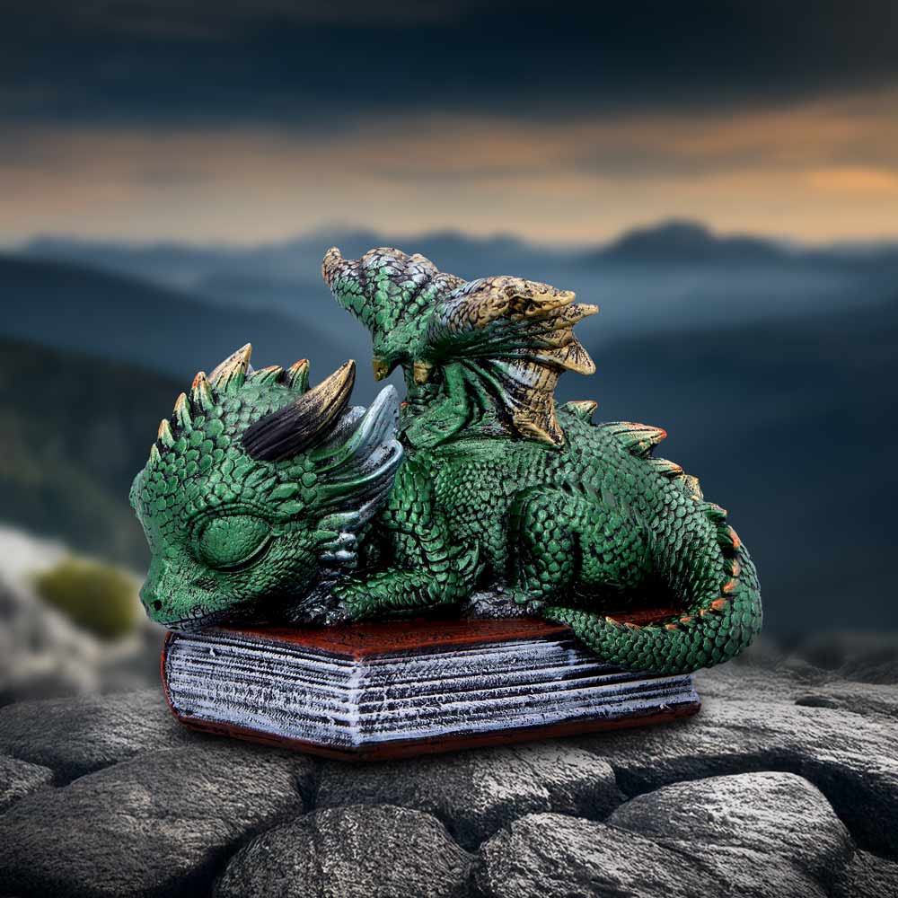 Green dragon figurine on a book with detailed scales and wings on display