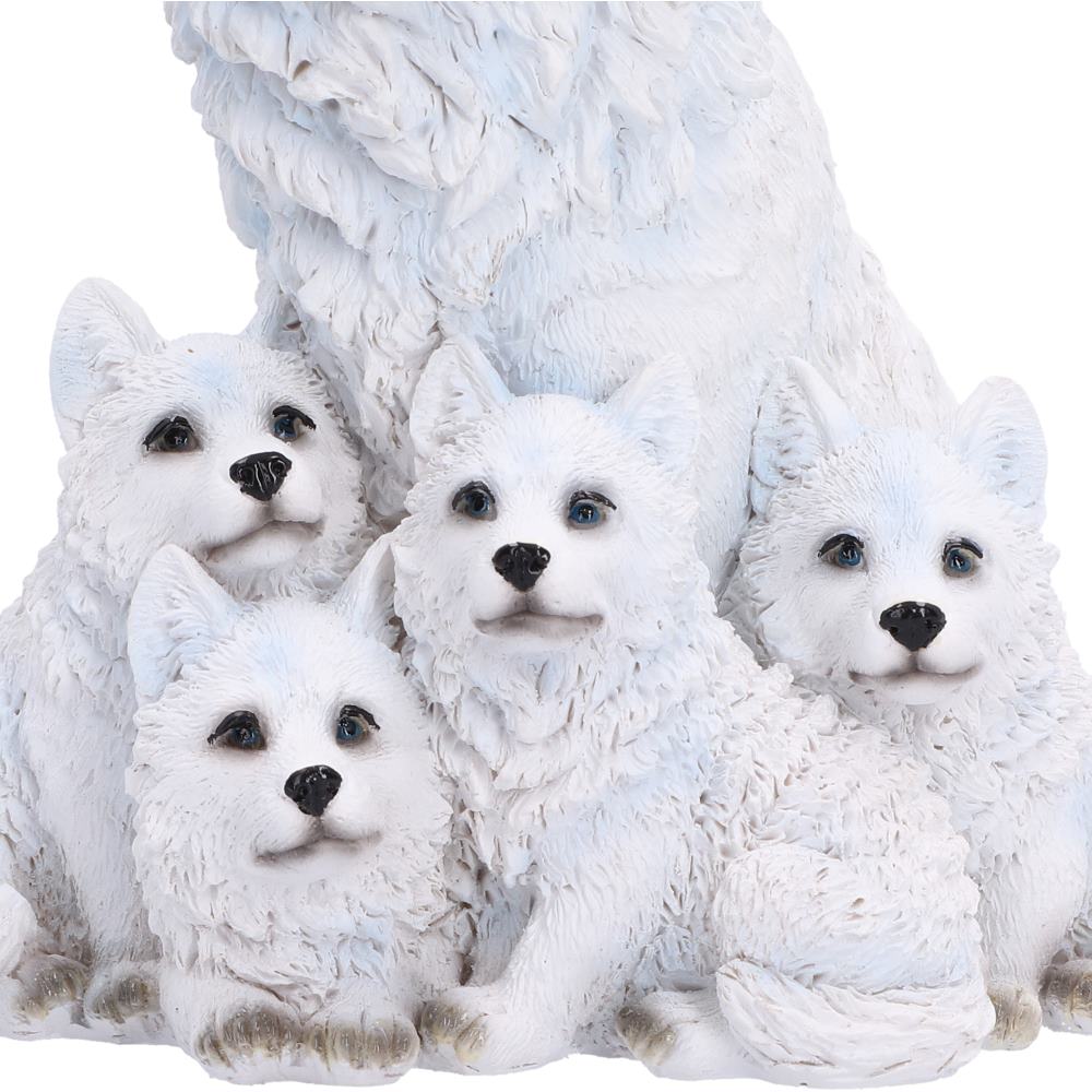 Close up of a white arctic wolf family figurine featuring a large adult wolf and four pups,
