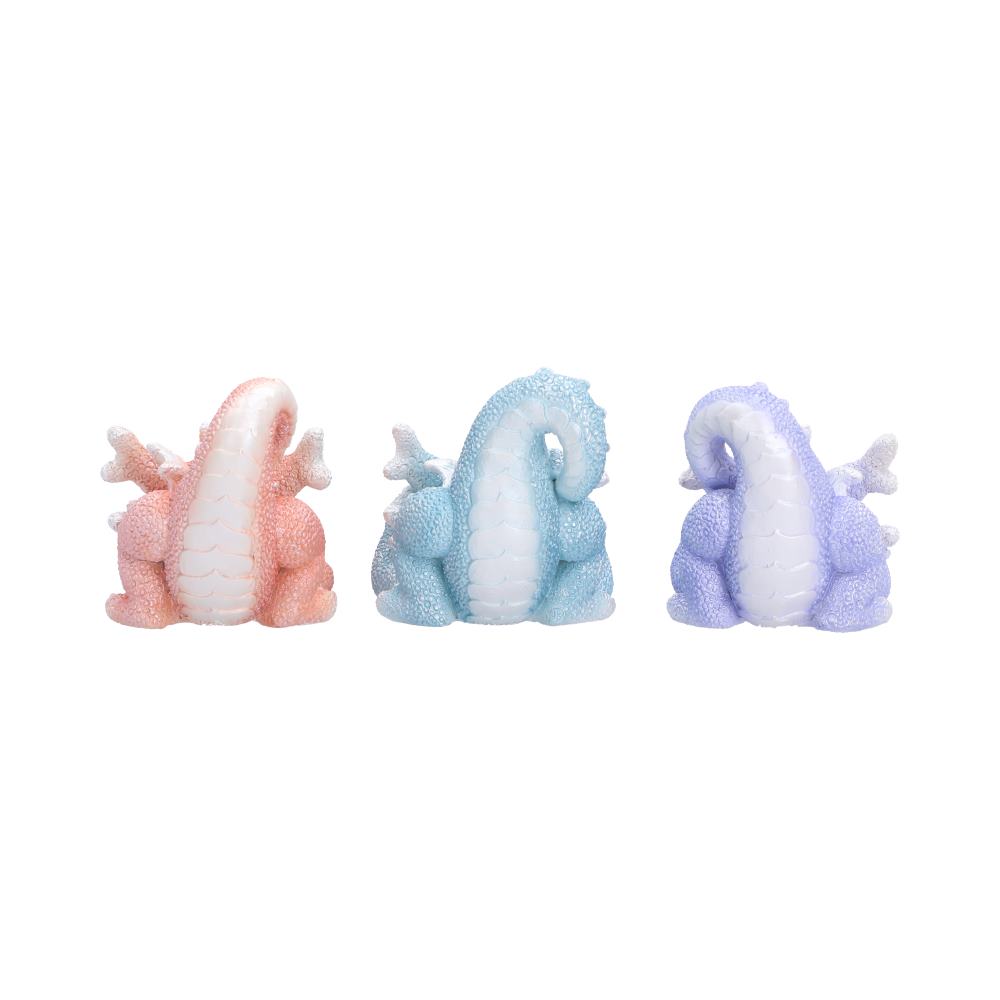 Rear view of Three Wise Coralscale Dragonlings figurines in pastel colors, shown side by side. The left dragon is pink and white, the center dragon is light blue and white, and the right dragon is lavender and white.
