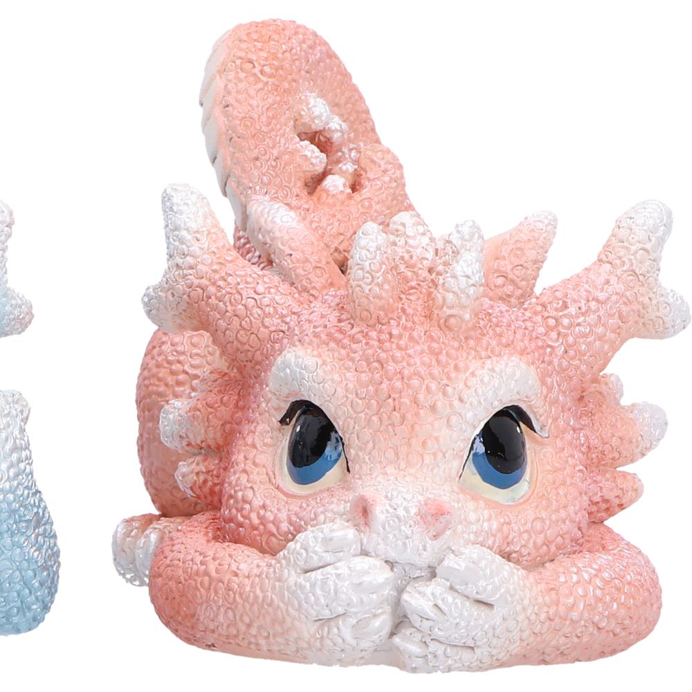 Pink Coralscale Dragonling miniature fantasy figurine with textured skin, large blue eyes, and white accents on its horns, hands, and tail.