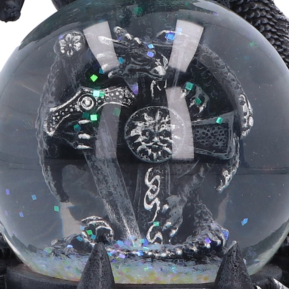 Close-up of the smaller dragon clutching a cross inside the Dragon’s Dominion globe