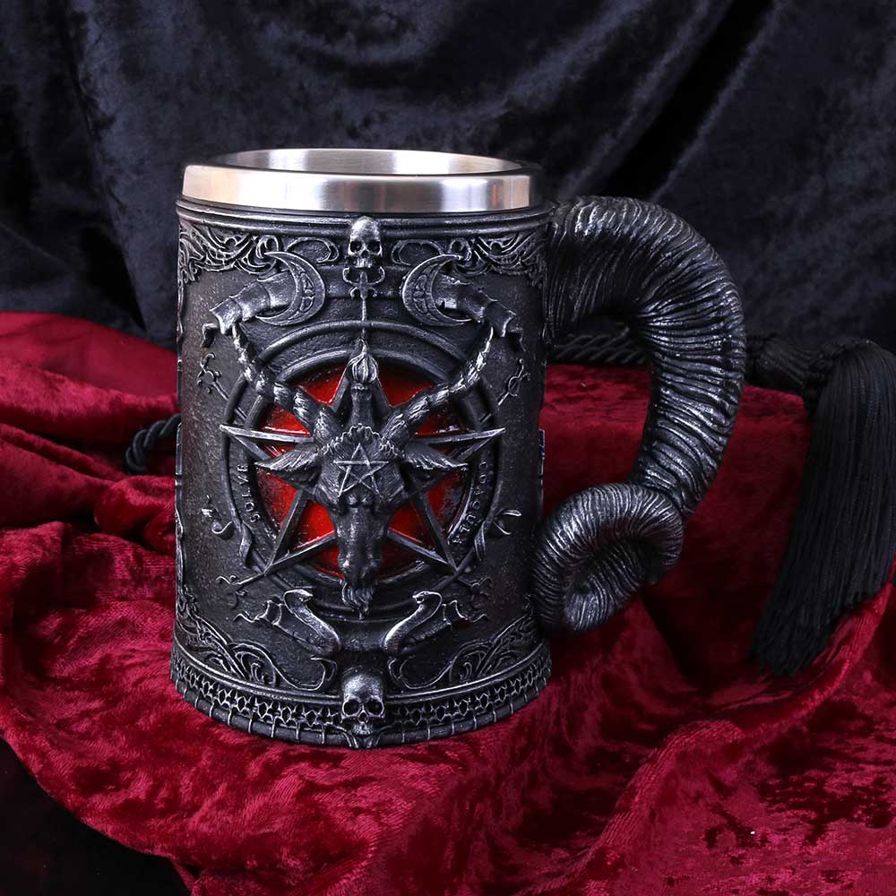 A black Nemesis Now Baphomet-themed tankard with a goat's head design on the handle, a pentagram, and two crescent moons on the body on display
